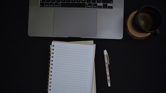 Author workspace with laptop and notebook