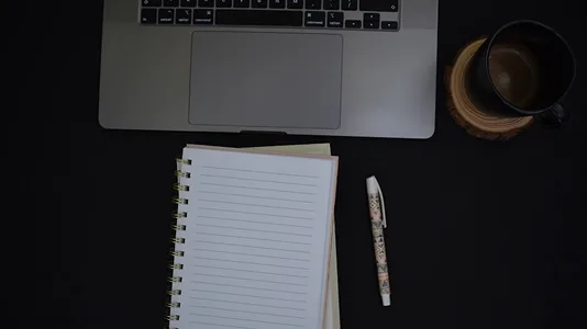 Author workspace with laptop and notebook